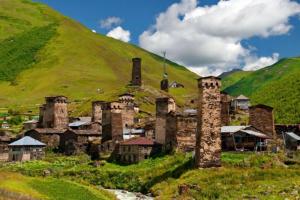 un vecchio edificio in mezzo a una verde collina di Old Tower Guesthouse - kafe ushguli a Ushguli