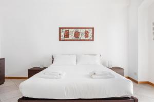 ein Schlafzimmer mit einem weißen Bett und zwei Nachttischen in der Unterkunft Italianway-Cerano in Mailand