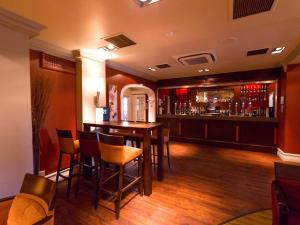 a bar with chairs and a table in a room at Gainsborough House Hotel in Kidderminster