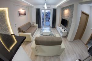 a living room with a couch and a tv at Diva Lux Apartman in Belgrade