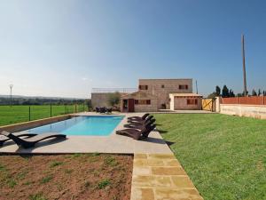 a swimming pool with lounge chairs in a yard at Belvilla by OYO Vinagrella in Muro