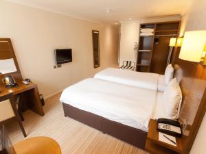 a hotel room with a bed and a desk at Gainsborough House Hotel in Kidderminster +35 photos