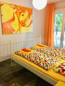 a bed with a colorful comforter in a room at Flower Garden in Mati