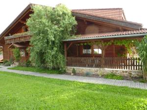 a wooden house with a fence and a green yard at Restaurace Vráž in Trhové Sviny