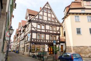 ein Gebäude in einer Straße mit einem davor geparkten Auto in der Unterkunft Hotel Bremer Schlagd in Hannoversch Münden