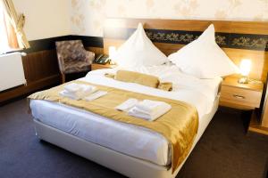 ein Hotelzimmer mit einem großen Bett, auf dem Handtücher lagen in der Unterkunft Hotel Bremer Schlagd in Hannoversch Münden