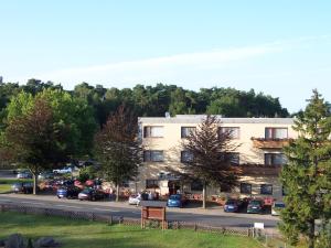 un bâtiment avec des voitures garées dans un parking dans l'établissement Hotel-Restaurant Fuchs, à Handeloh