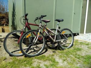 dwa rowery zaparkowane obok siebie na trawie w obiekcie Okari Cottage w mieście Cape Foulwind