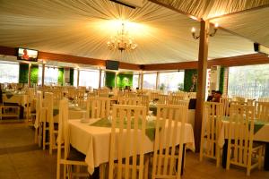a dining room with white tables and white chairs at Hotel Atlantic in Adjud