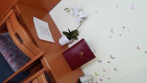 a bedroom with a desk with a plant and butterflies on the wall at Gastehaus Melcher in Villach