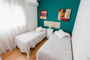 カディスにあるAtico Centro Historicoの緑の壁のベッドルーム1室(ベッド2台付)