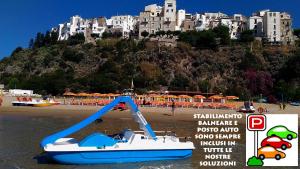 un barco en la playa frente a un gran edificio en Casa Vacanze Vespucci 4, en Sperlonga