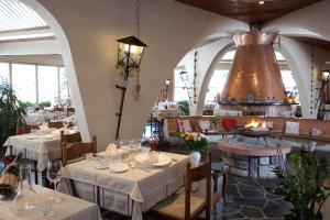 a restaurant with white tables and chairs and a chandelier at Grand Hotel de Valloire et du Galibier in Valloire