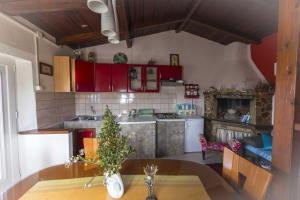 une cuisine avec des placards rouges et une table avec un arbre dans l'établissement Holiday home Rusticana***Sali, Dugi otok, à Sali