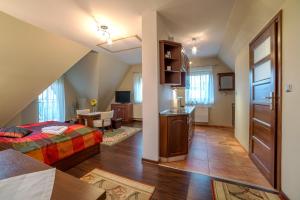 sypialnia z łóżkiem i salonem w obiekcie Janówka Apartamenty w mieście Kościelisko