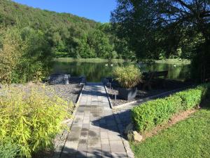 a walkway next to a lake with a bench at Ferienwohnung Hankel in Hemfurth-Edersee