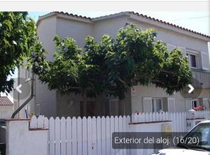 a white fence in front of a house at Casa _pareada con piscina y jardin privado in Torredembarra