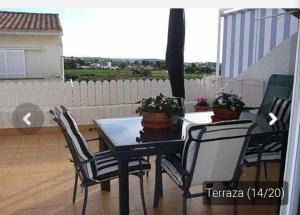 a black dining table and chairs on a balcony at Casa _pareada con piscina y jardin privado in Torredembarra