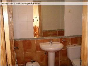 ein Badezimmer mit Waschbecken, Toilette und Spiegel in der Unterkunft Casa Rural Valdecorneja in Hoyorredondo + 7 Fotos