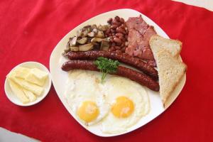 a plate of breakfast food with eggs sausage beans and bread at Inn Kochevnik in Cholpon-Ata