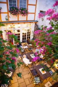 eine Außenterrasse mit Tischen, Stühlen und Blumen in der Unterkunft Landhotel Becker in Kamp-Bornhofen