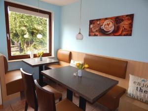 維斯馬的住宿－Pension am Burgwall，餐厅设有2张桌子和椅子以及窗户。