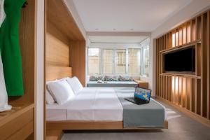 1 dormitorio con 1 cama y mesa con ordenador portátil en King's Blue, Urban Suites en Heraclión