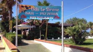 a blue sign in front of a bar and pizzeria at Il Melograno in Nicotera Marina +38 photos