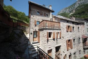 ein altes Steingebäude mit Holzfenstern auf einem Berg in der Unterkunft Albergo Diffuso Valcellina e Val Vajont in Casso in Casso