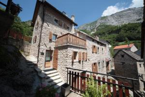 een oud stenen gebouw met trappen en een berg bij Albergo Diffuso Valcellina e Val Vajont in Casso in Casso