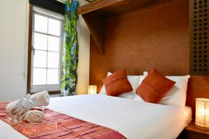 um quarto com uma grande cama branca com janela em Mojo Lodge Hakuba em Hakuba
