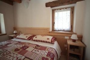 ein Schlafzimmer mit einem Bett und einem Fenster in der Unterkunft Albergo Diffuso Valcellina e Val Vajont in Casso in Casso