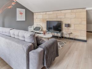 a living room with a couch and a tv at Notre Dame Apartment in Bordeaux