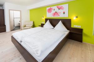 布倫的住宿－Gasthof im Almetal，一间卧室设有一张大床和绿色的墙壁