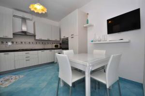 a kitchen with a white table and white chairs at Apartments Cetara in Cetara