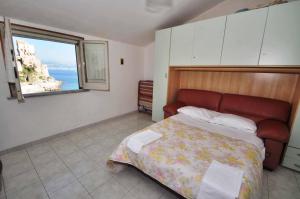 una camera con letto e vista sull'oceano di Apartments Cetara a Cetara
