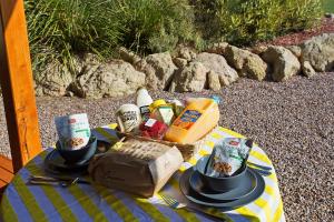 a picnic blanket with two cups and a basket of food at Anchors Port Campbell in Port Campbell