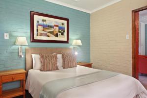 a bedroom with a large bed with blue walls at Baywater Village in Sedgefield