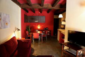 a living room with red walls and a table with chairs at Estrella rural casa rural en la Sierra de Madrid in Buitrago del Lozoya