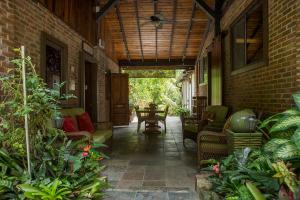 un patio con sofás y sillas en un edificio de ladrillo en El Yunque Rainforest Inn en Río Grande