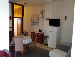 a small room with a table and a kitchen with a refrigerator at Apartment Katica in Crikvenica