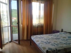 a bedroom with a bed and sliding glass doors at Villa Visoka in Balchik