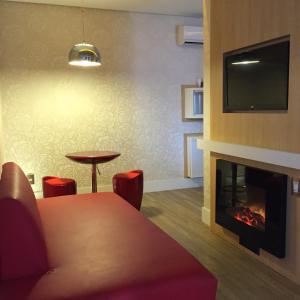 a living room with a table and a fireplace at Lual Motel Sorocaba-SP in Sorocaba