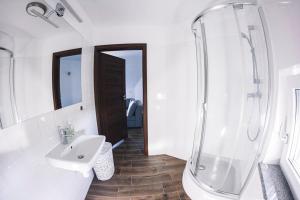 ein weißes Bad mit einem Waschbecken und einer Dusche in der Unterkunft Villa Tower Nad Jeziorem Nyskim in Skorochow