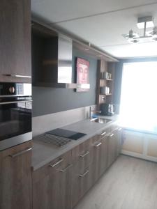 a kitchen with wooden cabinets and a stove top oven at Slapen in Dordrecht in Dordrecht