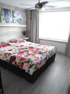 a bedroom with a bed with a floral comforter at Slapen in Dordrecht in Dordrecht