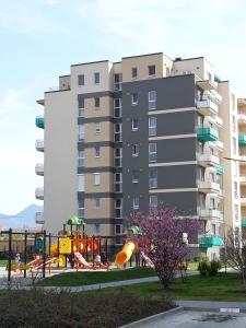 un gran edificio de apartamentos con un parque infantil delante de él en Avantgarden Apart, en Brasov