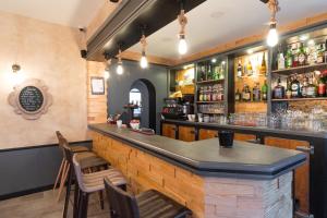a bar in a restaurant with a counter and chairs at Hôtel des Beaux Arts in Chambéry