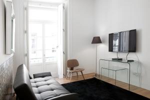 een woonkamer met een bank en een televisie bij Lisbon Serviced Apartments - Baixa in Lissabon