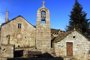 an old stone church with a cross on top of it at Chambre d'hote de la Fage in La Fage
